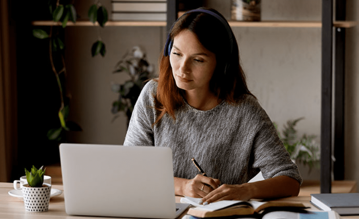 Pessoa participando de reunião online e fazendo anotações, representando diferentes modelos de negócios na internet