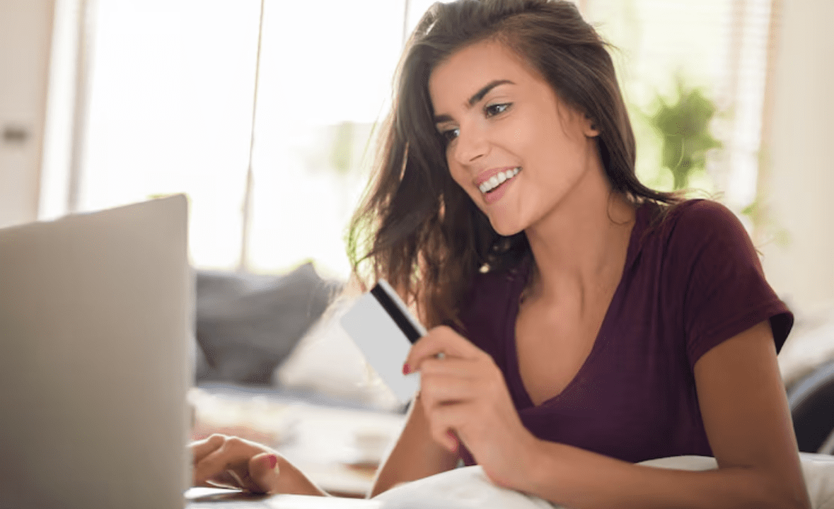 Entenda como vender todo dia na Braip com produtos físicos, representado por pessoa usando cartão de crédito e laptop